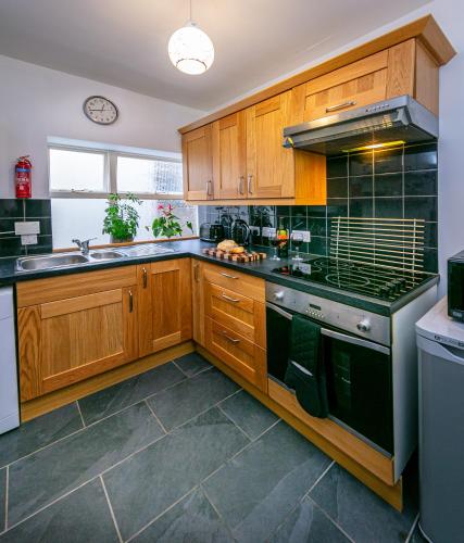 a kitchen with wooden cabinets and a stove top oven at Spacious Ground Floor Apartment in Keswick