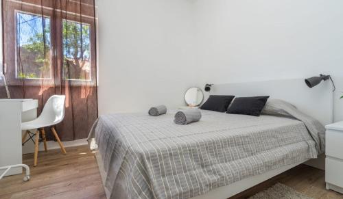 a white bedroom with a bed and a mirror at Apartman LIS in Pomer