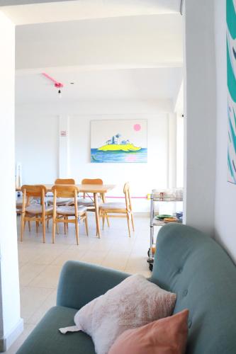 a living room with a blue couch and a table at Hotel Casa Mandarine , Amazing Private Rooms w Balcony, Rooftop, Hammocks, AC, SmarTV, 100mbs! in Zihuatanejo