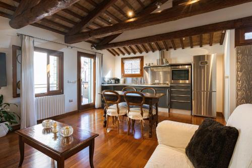 a living room with a table and a kitchen at San Marco Luxury Loft with Terrace in Venice