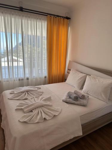 a bed with two towels on it with a window at yenivadi in Antalya