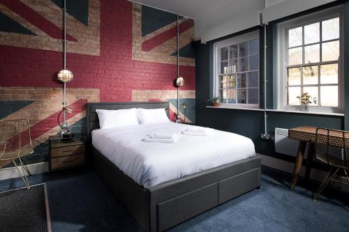 een slaapkamer met een bed en een rode bakstenen muur bij The Quarters in Weedon Bec