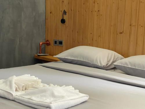 two beds with white towels on top of them at Rock Forest in Sattahip