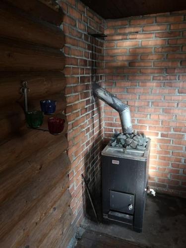 a brick wall with a stove in a brick room at Mökki Salakka Rääkkylä Pohjois-Karjala in Nieminen