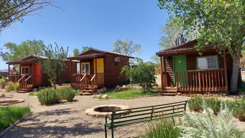 艾斯卡蘭特的住宿－Canyons Of Escalante RV Park，庭院里几间小屋,设有长凳