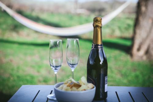 a bottle of champagne and two wine glasses on a table at Cybi at Llanfair Hall in Llanfairpwllgwyngyll