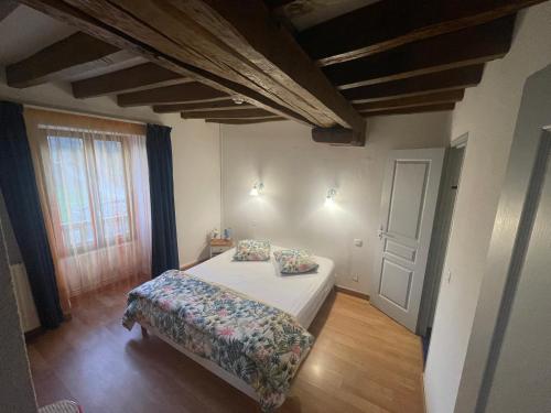 een slaapkamer met een bed met 2 kussens erop bij L'Auberge l'Orée du Bois in Aillières