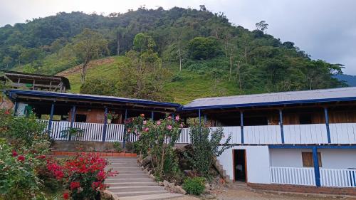 a building with a mountain in the background at Finca El Encanto del Guejar in Lejanías