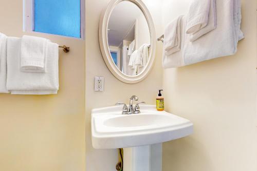a bathroom with a sink and a mirror and towels at Southernmost Retreat in Key West