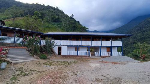 a house on a hill with mountains in the background at Finca El Encanto del Guejar in Lejanías