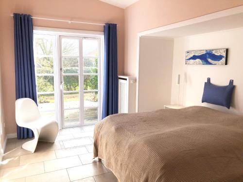 a bedroom with a bed and a large window at Oldsens - Wohnen zwischen Wind und Weite in Oevenum