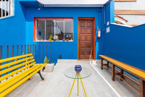 un bâtiment bleu avec un banc et une table dans l'établissement Hostel Casa Azul, à São Paulo