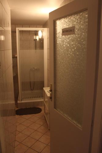 een badkamer met een douche en een glazen deur bij Back Private Budget Rooms in Bled