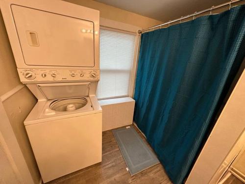 uma máquina de lavar roupa num pequeno quarto com uma janela em The Yellow Door 3-bedroom downtown near VT&RU em Radford