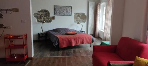 a bedroom with a bed and a red couch at al porticciolo in Trieste