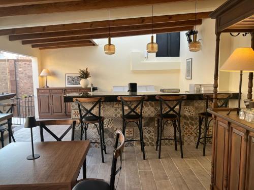 a kitchen with a bar with chairs and tables at Hotel Boutique Rincón de Luna in San Juan del Río