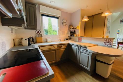 a kitchen with wooden floors and a red stove top oven at Nice house with pool near the city center in Hérouville-Saint-Clair