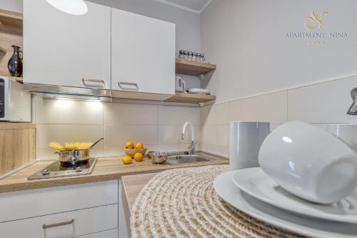 a kitchen with white cabinets and a sink and a counter top at Apartment Nina Pazin in Pazin