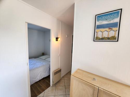 niewielka sypialnia z łóżkiem i zdjęciem na ścianie w obiekcie Le Green - Appt Houlgate vue sur le golf w mieście Houlgate