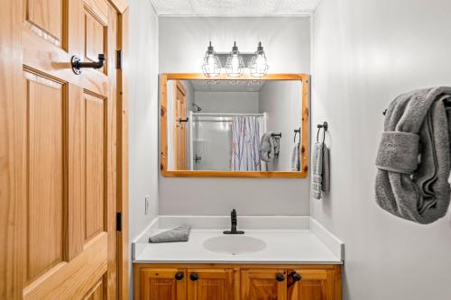 a bathroom with a sink and a mirror at The Sly Fox - Recently Updated/ Ideal PF Location in Pigeon Forge