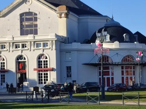 a large white building with cars parked in front of it at un nid d ' Amour in Cabourg
