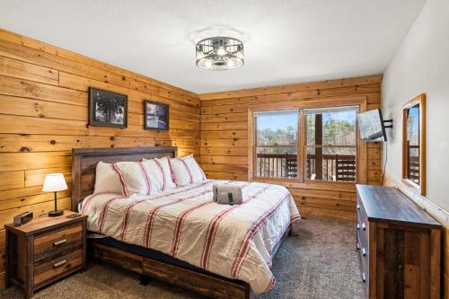 1 dormitorio con 1 cama y pared de madera en The Sly Fox - Recently Updated/ Ideal PF Location, en Pigeon Forge