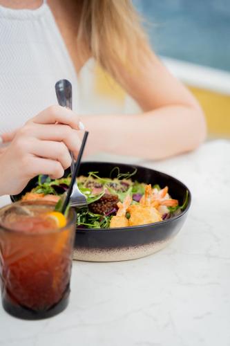 a woman sitting at a table with a bowl of food at Harbor Hotel & Casino Curacao in Willemstad