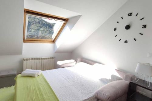 a bedroom with a bed and a clock on the wall at Alianza del Castillo in Ponferrada