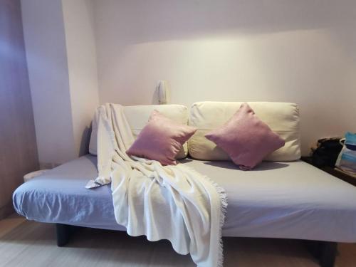 un sofá con 3 almohadas en una habitación en Elite Pod 807 Knightsbridge Makati en Manila