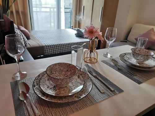 a table with plates and glasses on top of it at Elite Pod 807 Knightsbridge Makati in Manila