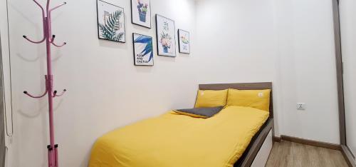 ein kleines Schlafzimmer mit einem gelben Bett in einem Zimmer in der Unterkunft NK#Homestay#Vinhomes#Oceanpark#2PN#C22 in Gia Lâm Pho