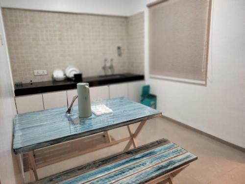 a kitchen with a blue table in a room at La vaccanza Suite -403 in Pune
