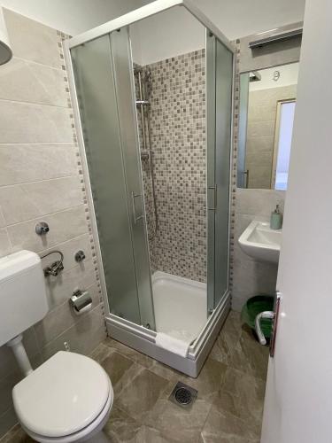 a bathroom with a shower and a toilet and a sink at Diana Rooms and Apartments in Starigrad