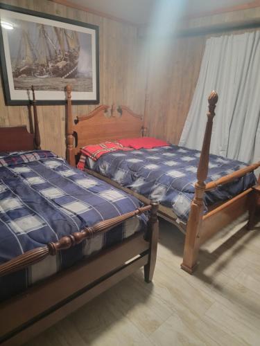 - 2 lits jumeaux dans une chambre avec un bateau dans l'établissement Daves shallow lake lodge at reelfoot lake, à Samburg