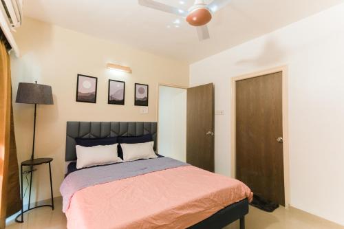 a bedroom with a bed and a ceiling fan at La vaccanza Suite -403 in Pune