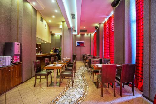 a restaurant with wooden tables and chairs and red curtains at Egnatia Hotel in Thessaloniki