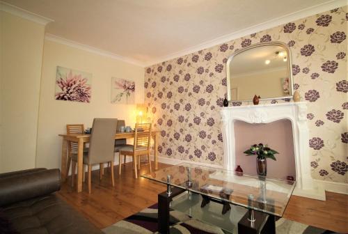 a living room with a table and a mirror at Boswell-Large Balcony Apartment-Town & Racecourse in Doncaster