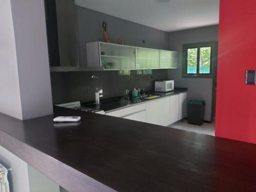 uma cozinha com uma bancada preta e uma parede vermelha em Casasanisidrosr em San Rafael