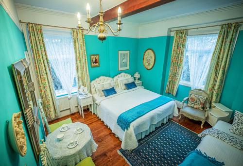 a blue bedroom with a bed and a chair at Dawson Place, Juliette's Bed and Breakfast in London