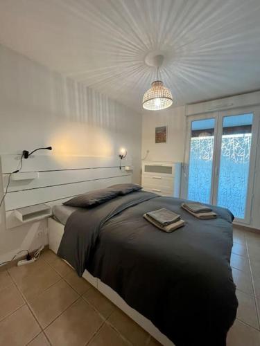 een slaapkamer met een groot bed in een witte kamer bij Superbe appartement - DABNB in Limoges