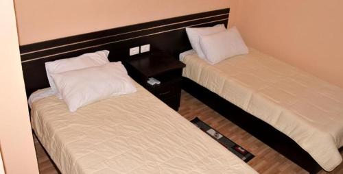 2 Betten in einem Hotelzimmer mit Röcken in der Unterkunft Garden Hotel in Gjirokastër