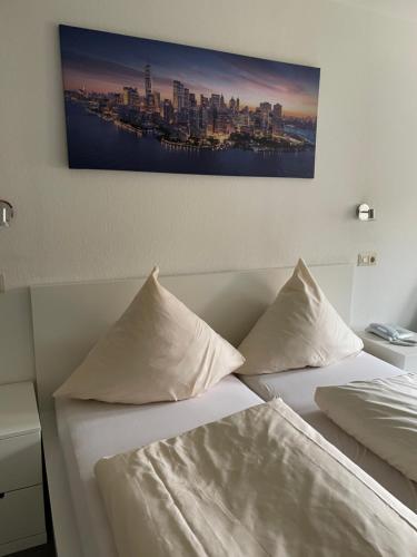 a bedroom with two beds and a painting on the wall at Zum Deutschen Heinrich in Gifhorn