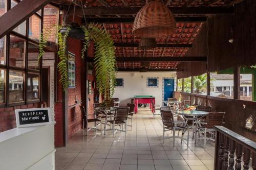 a patio with chairs and tables and a table with a table at Pousada Casa da Penha in Abraão
