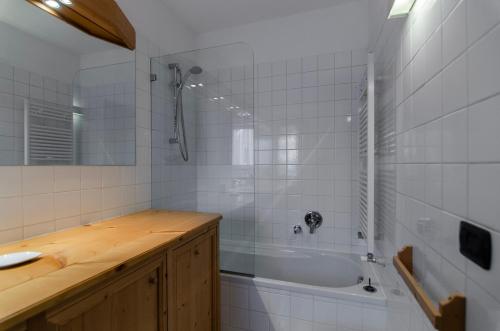 een badkamer met een douche, een bad en een wastafel bij Sweet Cristallo in Cortina dʼAmpezzo
