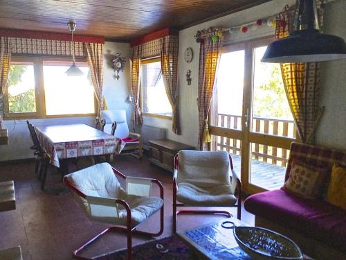 un salon avec un canapé, des chaises et une table dans l'établissement Appartement dans chalet au pied des pistes, à Saint-Lary-Soulan
