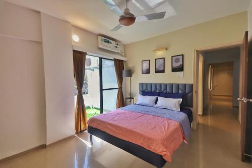 een slaapkamer met een bed en een plafondventilator bij La vaccanza Suite -403 in Pune