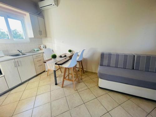 a kitchen with a table and chairs and a bed at Sidari Vibes On The Beach in Sidari