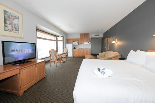 a hotel room with a large bed and a flat screen tv at Prime Hotel in Fort McMurray