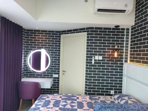 - une chambre avec un lit et un miroir mural dans l'établissement Amore Apartment, à Kalisari