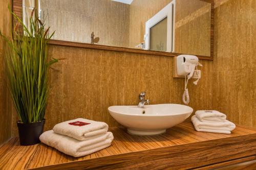 y baño con lavabo y toallas en la encimera. en Central Park Residence, en Brasov